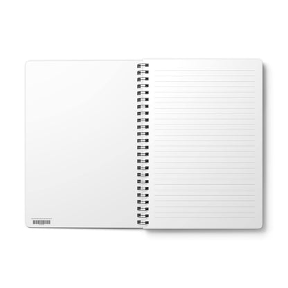 Open, spiral-bound notebook with blank, lined pages. The left page is blank, while the right page features horizontal lines for writing. The notebook has a black spiral binding and a barcode at the bottom of the left page.