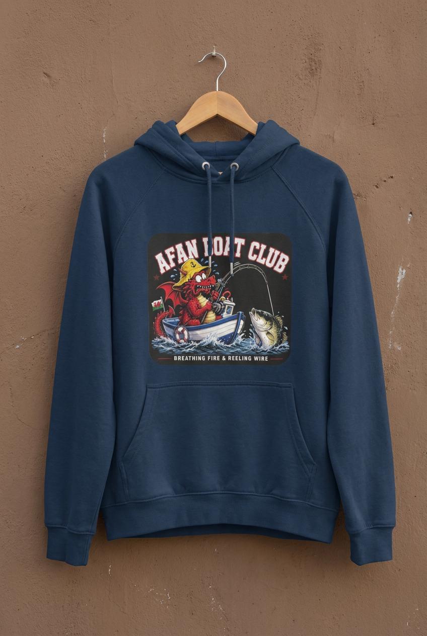 Navy blue Afan Boat Club Welsh Dragon hoodie on a hanger, red dragon breathing fire and reeling wire print, weathered concrete backdrop.