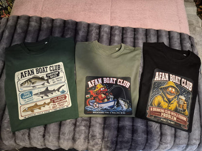 Three Afan Boat Club tees side by side in bottle green, earth green and black, showing colour and design range in a bedroom surrounding.