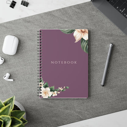 Product listing photo showing the A5 Plum Botanical spiral notebook styled next to stationery placed on a table runner.