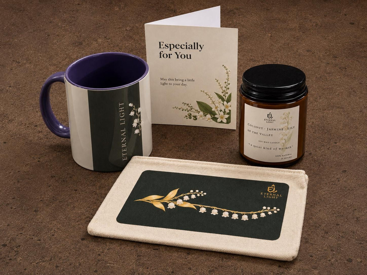 A curated arrangement of the Lily of the Valley ceramic mug, luxury candle, premium card, and zippered pouch displayed together on a rustic brown concrete floor.
