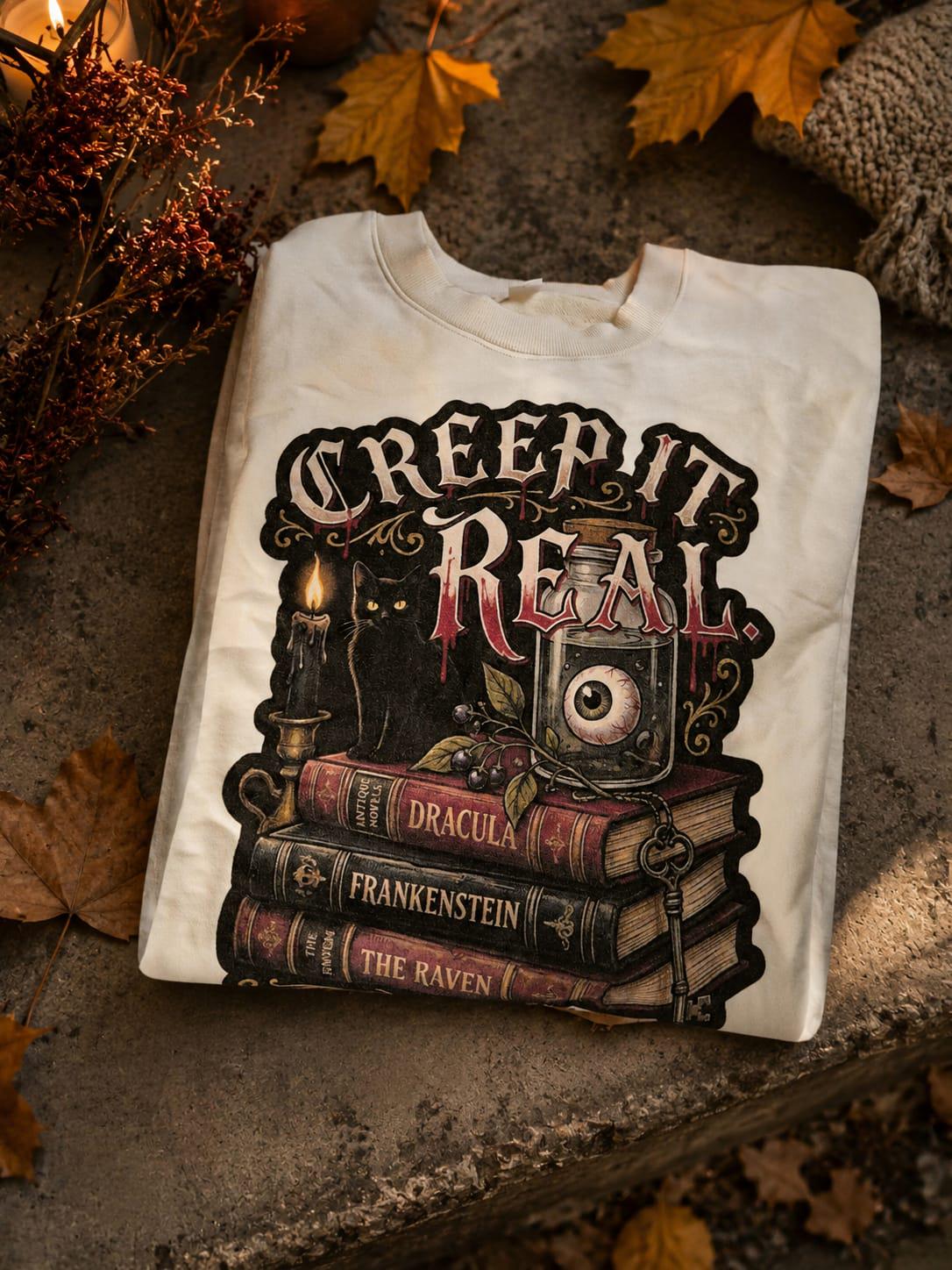 Cream Creep It Real heavyweight sweatshirt folded on warm concrete with autumn leaves and cosy seasonal styling.