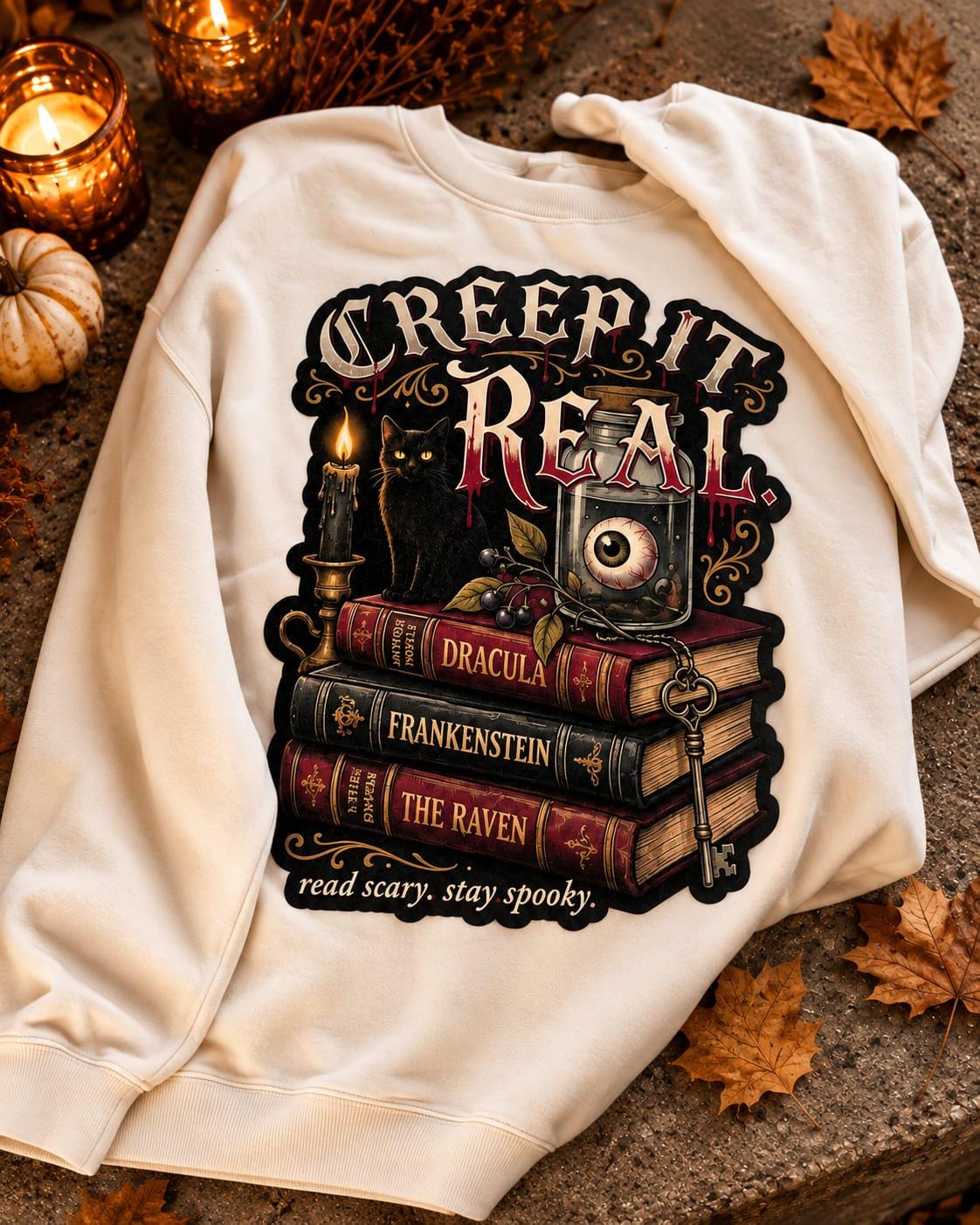 Gothic reading sweatshirt with Dracula Frankenstein and The Raven book design in cream black and autumn tones.