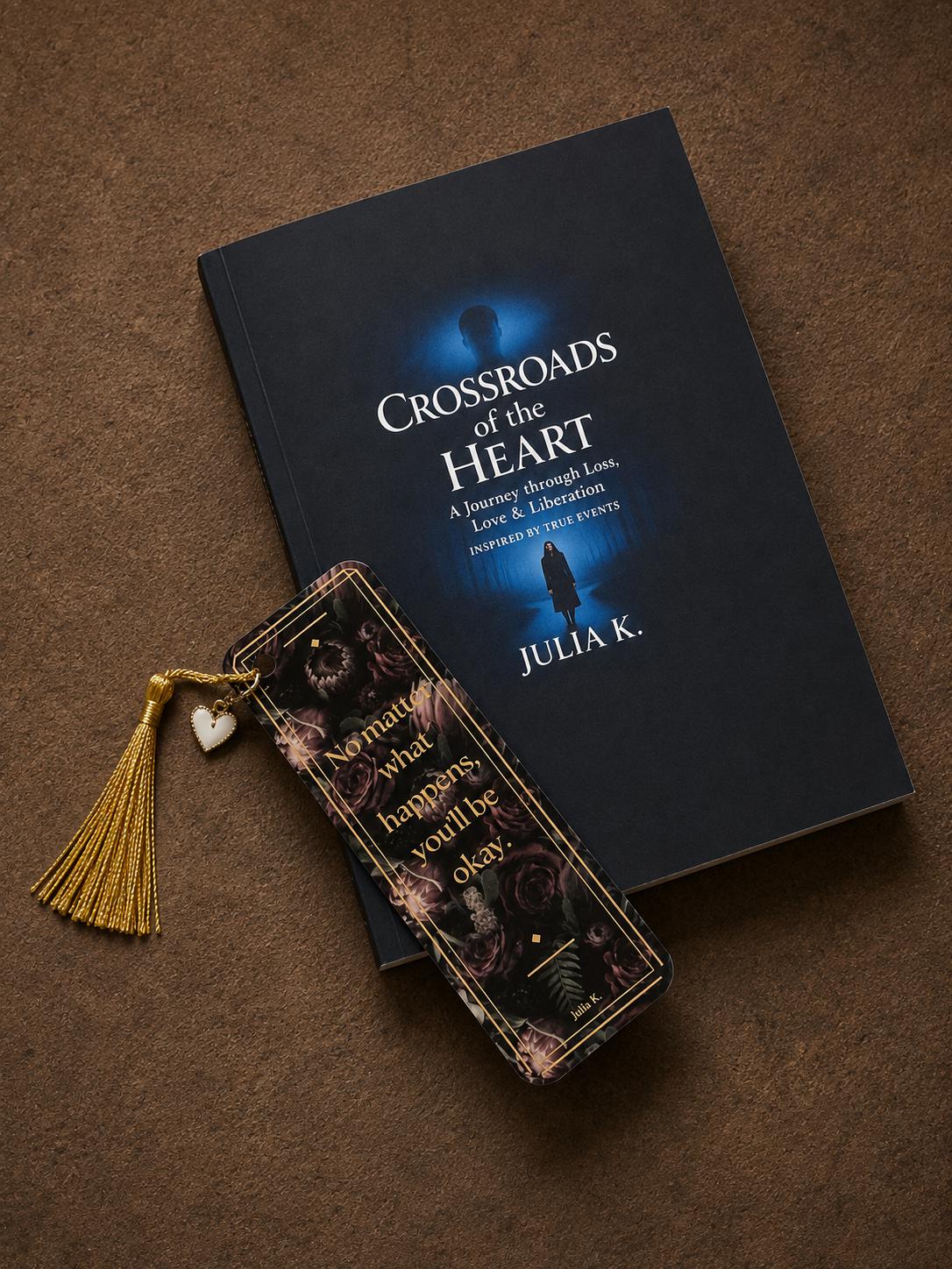 A custom bookish bookmark featuring a delicate gold tassel and a small heart charm, resting elegantly on the cover of a signed novel, "Crossroads of the Heart".